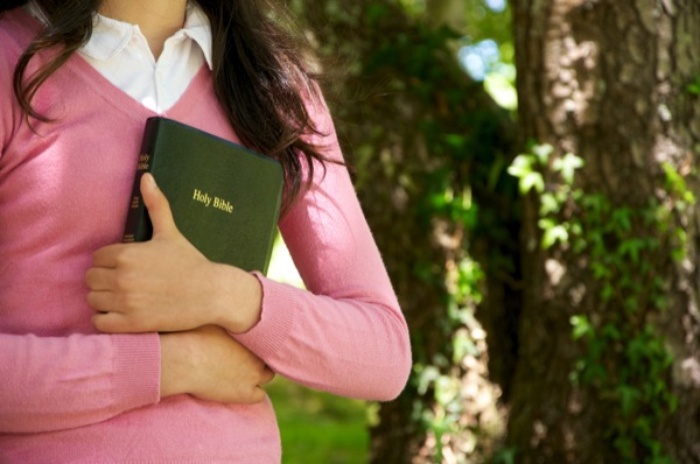 Woman holding the bible in her arms