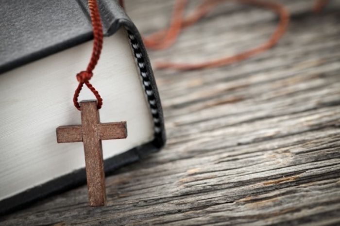 Bible with cross necklace laying on it