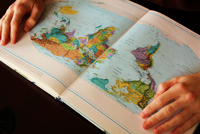 Person looking at open map of the world