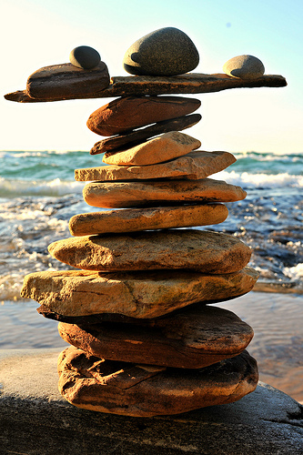 Rocks balancing on top of each other on ledge in front of the ocean